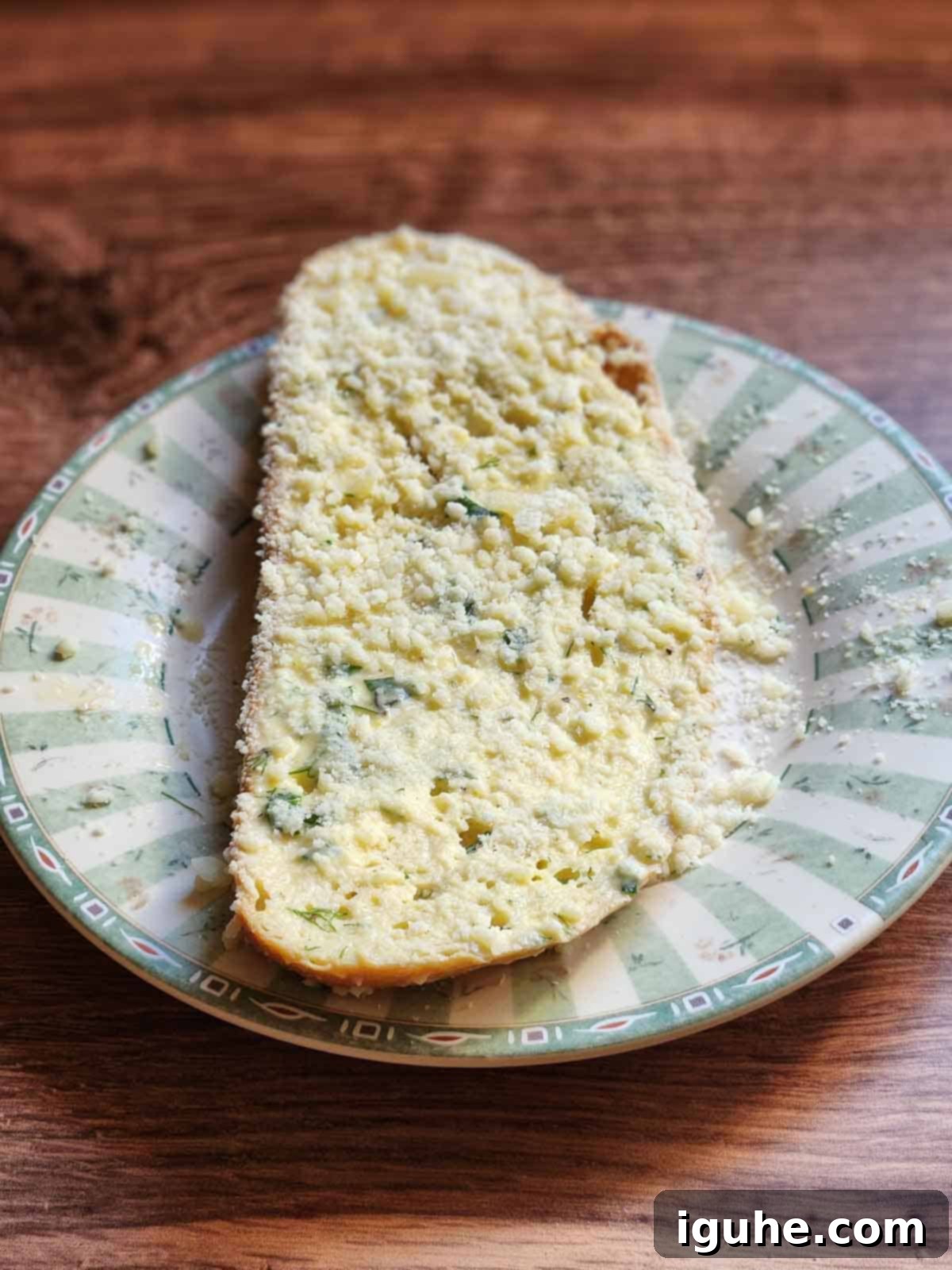Parmesan, Lemon and Herb Savory French Toast 7 Bread dipped in parmesan cheese on a green plate.
