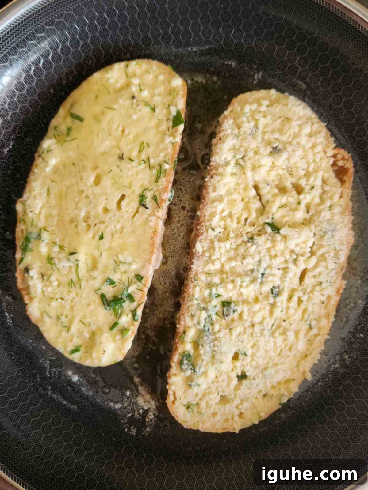 Parmesan, Lemon and Herb Savory French Toast 8 Two slices of French toast in a pan being sauteed.