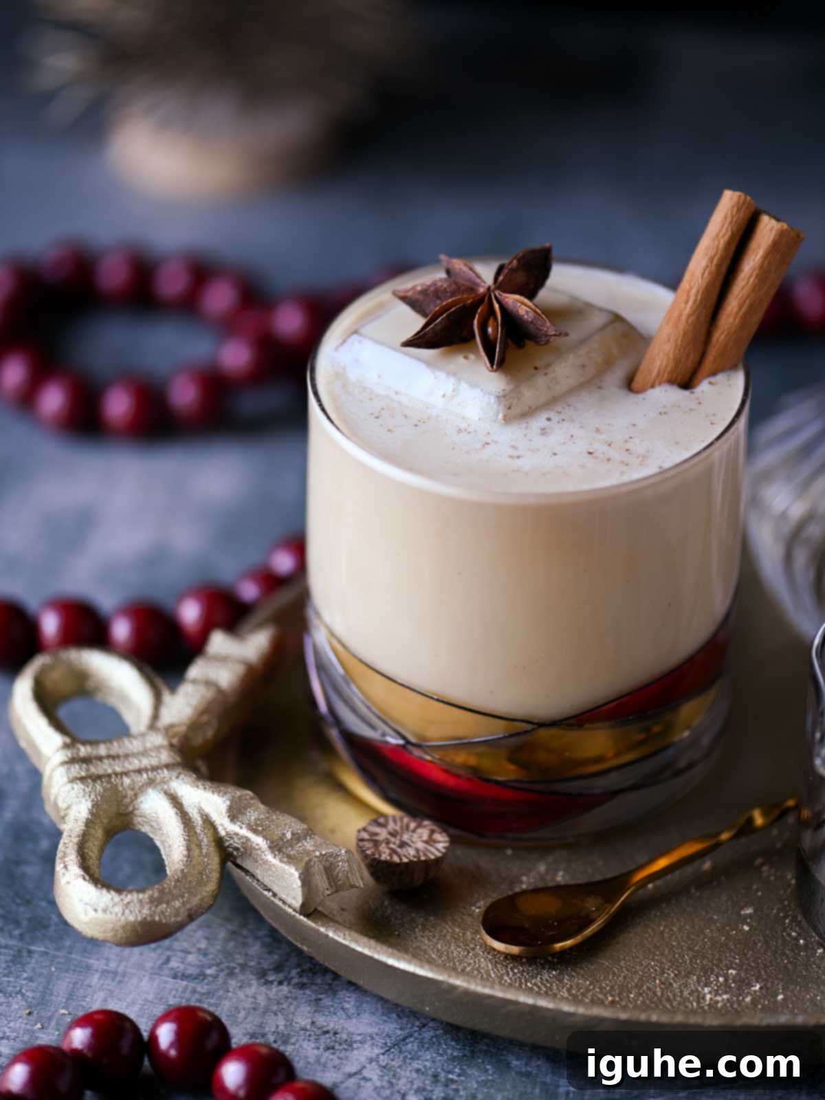 Close-up of a white Russian cocktail with star anise and cinnamon stick on top.