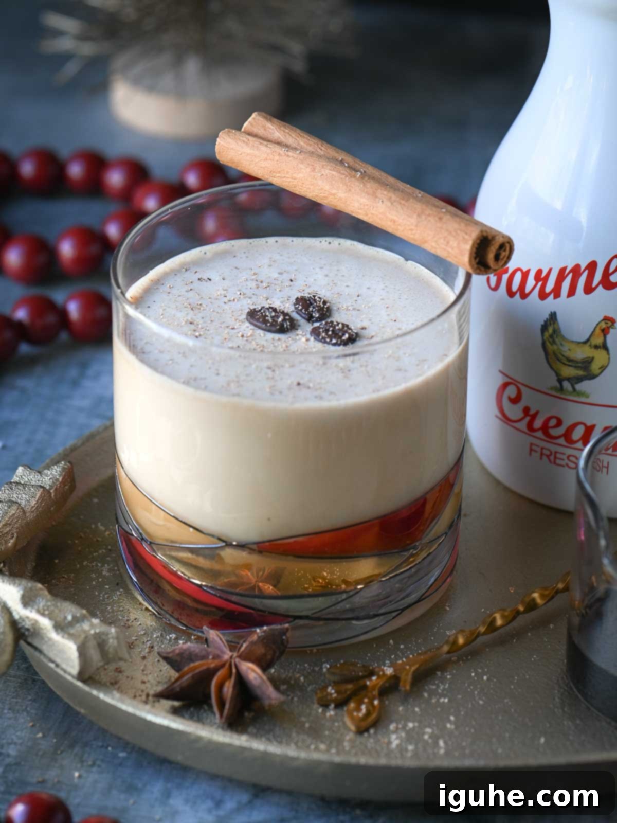 Close up of an eggnog White Russian drink in a clear glass garnished with coffee beans.