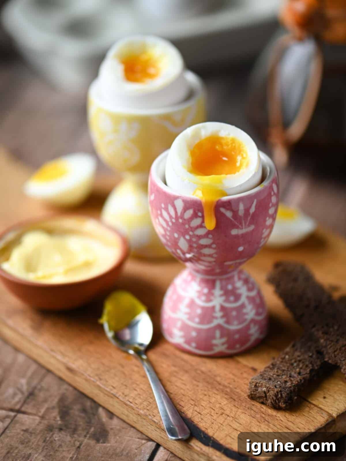 Perfectly Runny Eggs With Toasted Rye 3 Two perfectly soft boiled eggs in egg holders, with the golden yolk delicately dripping down the side.