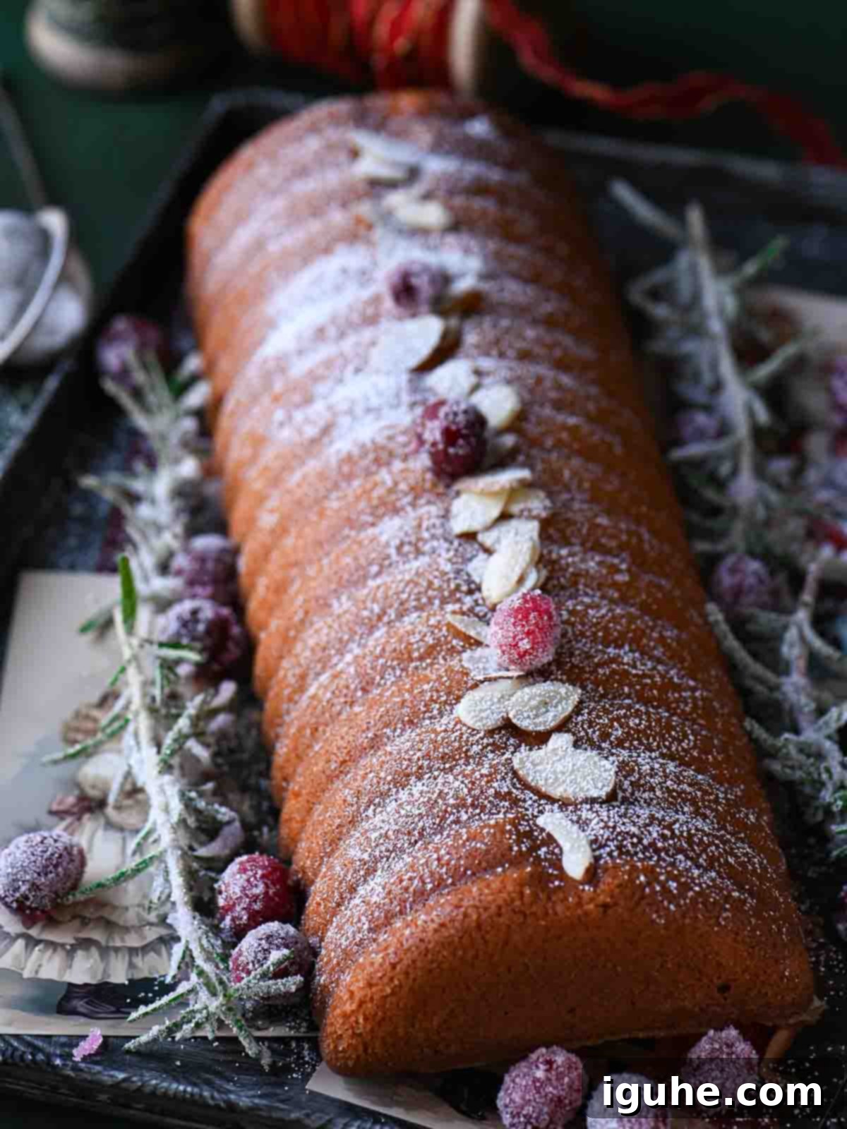 Almond cake close-up with almonds, cranberries and sugared rosemary. Highlighting the different decorating options for your Scandinavian almond cake.