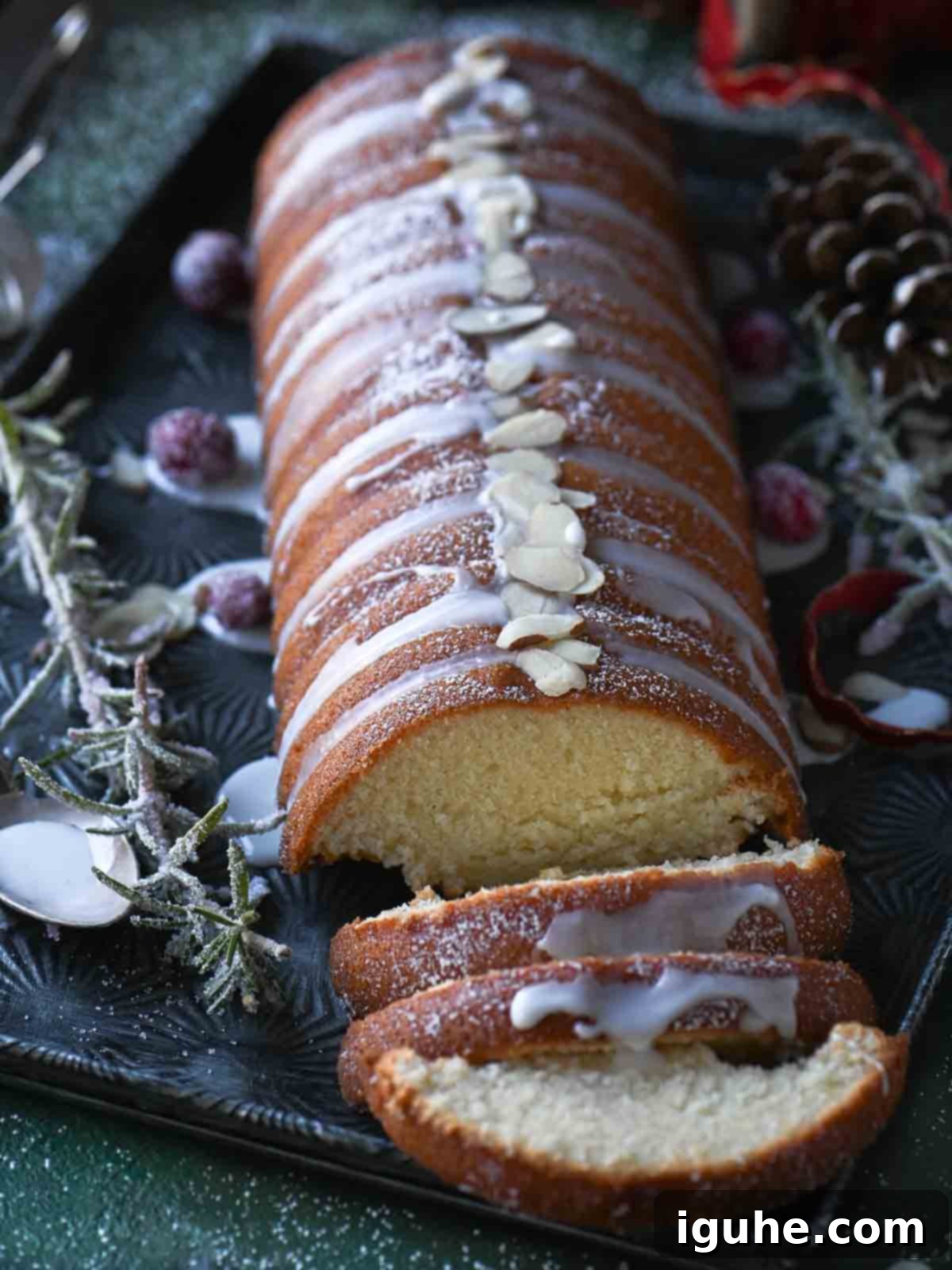 Angled view on an almond cake with icing on top and sugared cranberries. A perfectly decorated Scandinavian almond cake for the holidays.