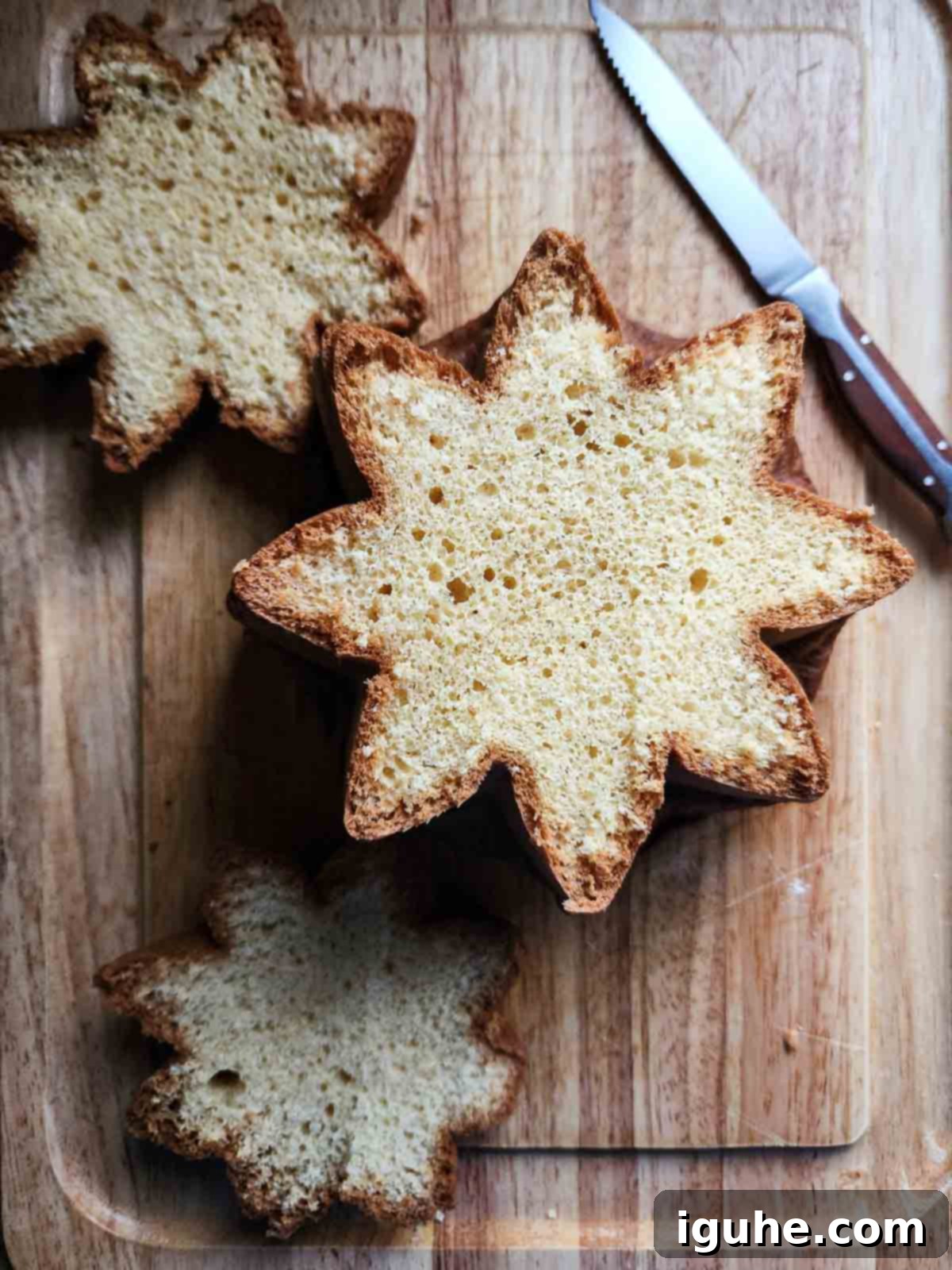 Overhead of sliced pandoro showing its star shape on a cutting board.