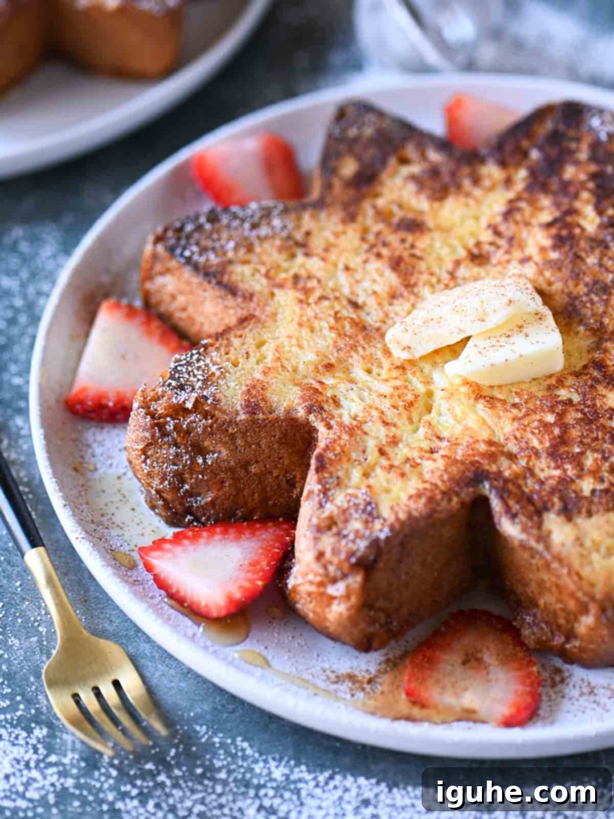 Angled view of star French toast with strawberries on a white plate.