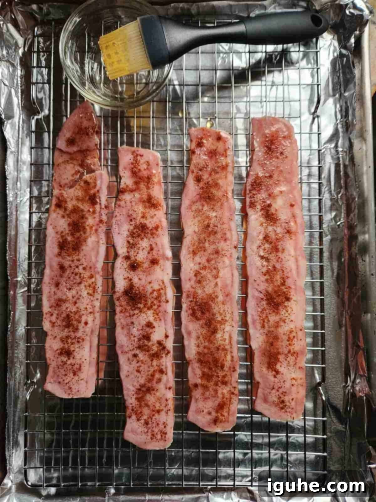 Honey Chipotle Turkey Bacon Bliss 6 Turkey bacon on a baking pan, generously sprinkled with chipotle seasoning for a smoky kick.