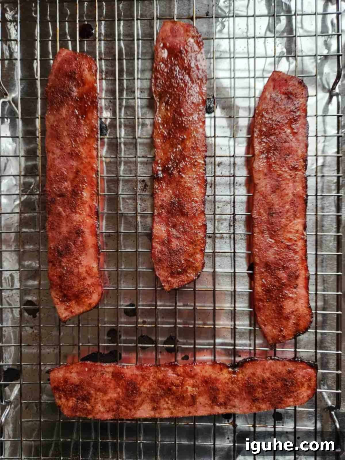 Honey Chipotle Turkey Bacon Bliss 7 Cooked honey chipotle turkey bacon on a baking tray, showcasing its perfectly crisp edges and caramelized surface.