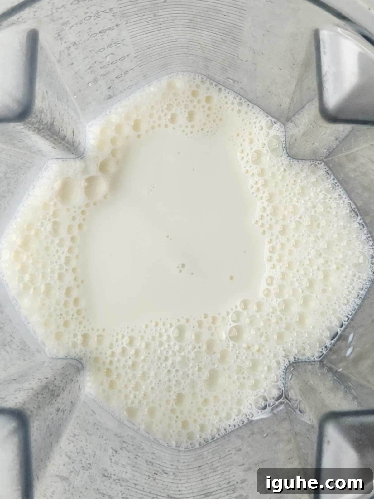 Strawberry Peach Bliss Smoothie 4 An overhead view of milk being poured into a blender.