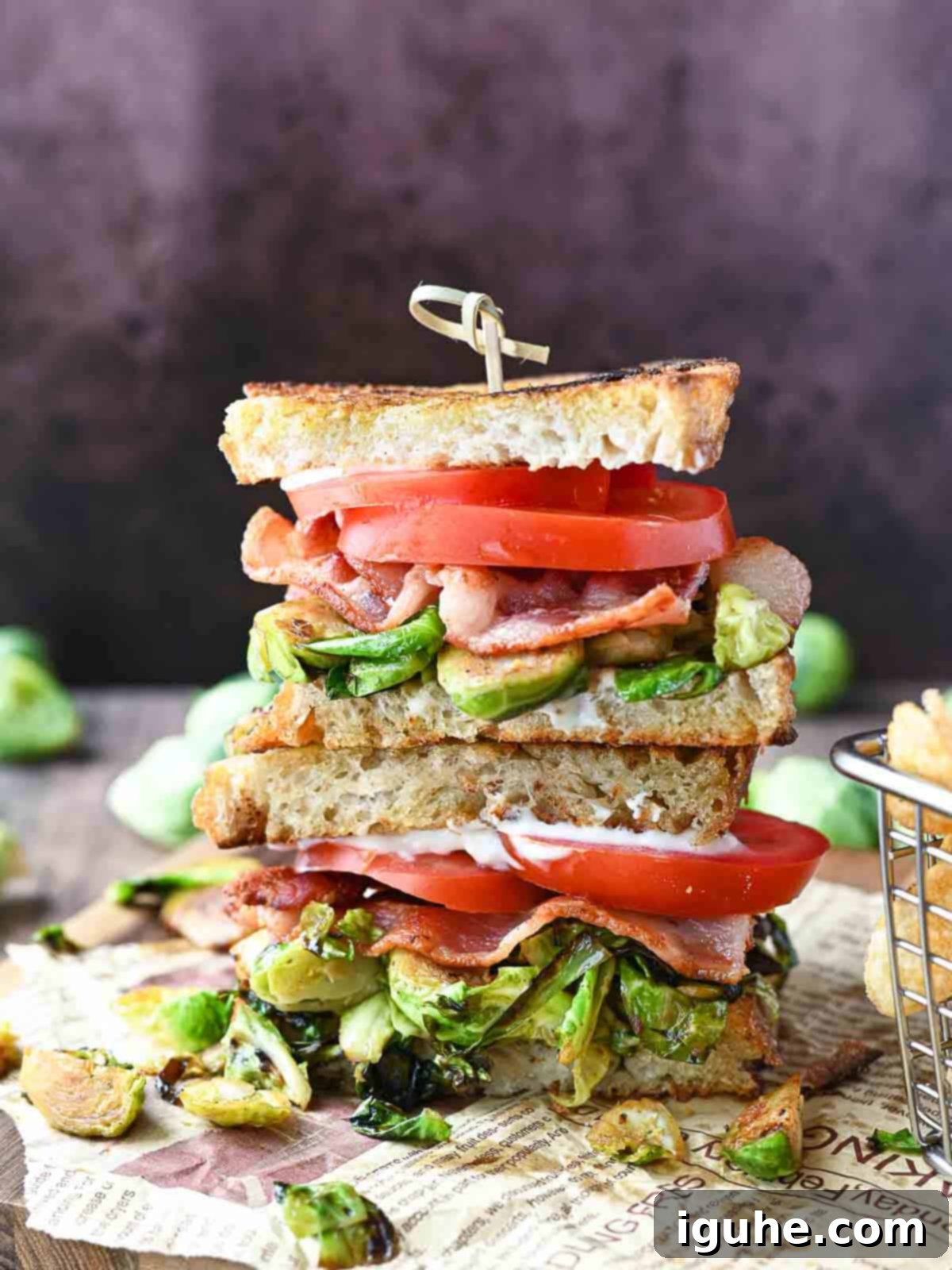 Crispy Brussels Sprout BLT 2 Brussel sprout BLT stacked on a wooden board.