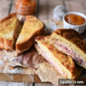 Close-up image of sliced Monte Cristo sandwiches on a wooden board with apricot jam. Ready to eat!